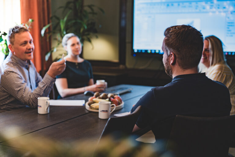 Planeringsmöte där personalen på Aircoil sitter samlade runt ett bord.